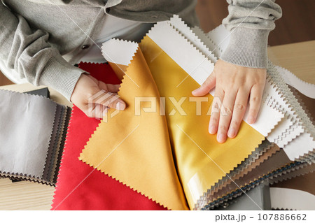 female designer with fabric color samples choosing textile for curtains 107886662