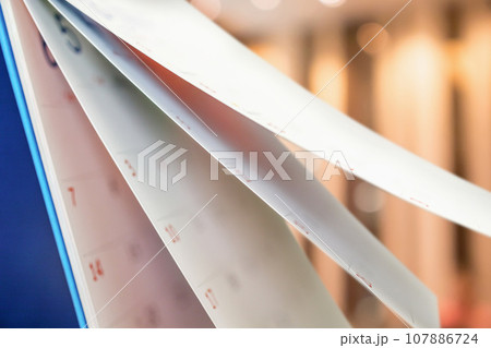Close up white paper desk calendar with blurred bokeh background appointment and business meeting concept Close up white paper desk calendar with blurred bokeh background appointment and business meeting concept 107886724