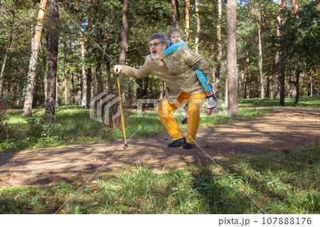 Grandfather walks with his granddaughter in the park. Grandfather walks with his granddaughter in the park. 107888176