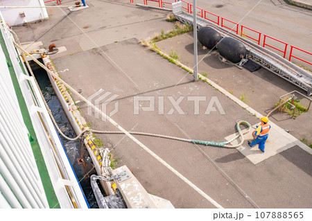埠頭ターミナル　出航　ホーサーの長さを調整する綱取り作業員 107888565