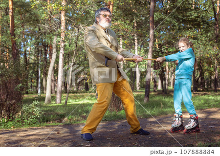 Grandfather walks with his granddaughter in the park. Grandfather walks with his granddaughter in the park. 107888884