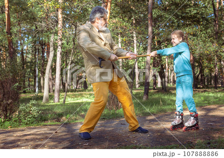 Grandfather walks with his granddaughter in the park. Grandfather walks with his granddaughter in the park. 107888886
