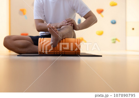 部屋でストレッチする若い男性 107890795