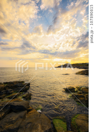 black sea scenery with rocks at sunrise. summer holiday season. cloudy weather. sunlight reflecting on the water surface black sea scenery with rocks at sunrise. summer holiday season. cloudy weather. sunlight reflecting on the water surface 107890815