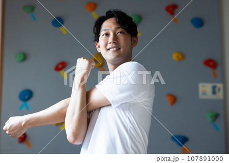ボルダリングジムに通う若い男性 107891000