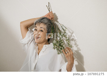 お花を持つグレイヘアの上品な日本人女性 お花を持つグレイヘアの上品な日本人女性 107891275
