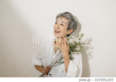 お花を持つグレイヘアの上品な日本人女性 107891284