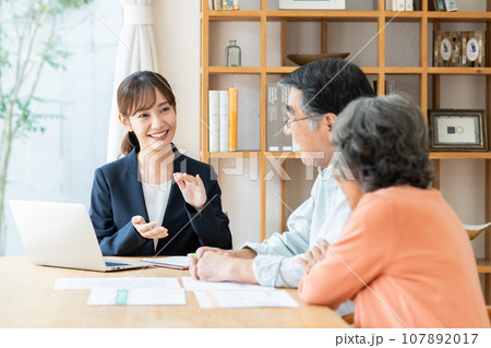 シニアの夫婦に説明する若いビジネスウーマン 107892017