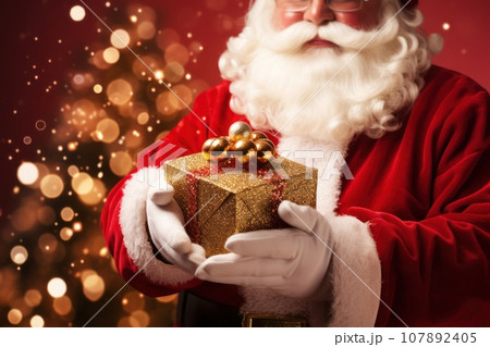 Santa Claus hands holding a gift box against surrounded by stylish golden bokeh on red background. Generative Ai 107892405