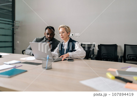 Remote view of female manager insurer consulting black male customer with laptop at meeting. Mature saleswoman or mentor showing online presentation of deal benefits talking convincing client teaching Remote view of female manager insurer consulting black male customer with laptop at meeting. Mature saleswoman or mentor showing online presentation of deal benefits talking convincing client teaching 107894419
