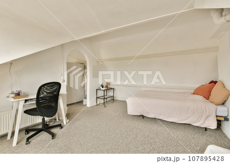 a bedroom with a bed, desk and computer on the floor in front of the window looking out to the outside a bedroom with a bed, desk and computer on the floor in front of the window looking out to the outside 107895428
