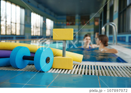 Aqua aerobics class gymnastics training lesson at health club with swimming pool Aqua aerobics class gymnastics training lesson at health club with swimming pool 107897072