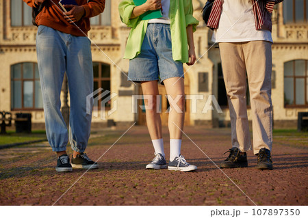 Group of smart students standing outdoors at campus Group of smart students standing outdoors at campus 107897350