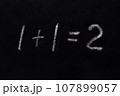 Simple math equation 1 1 2 written school board chalk. Blackboard equations one plus one equals two written black board background. 1 plus 1 equals 2 writing chalkboard background. Elementary school 107899057