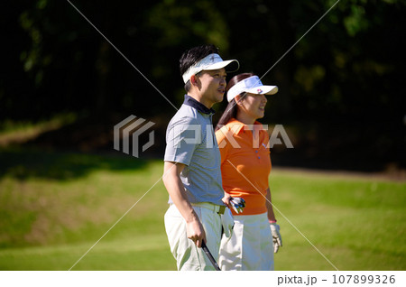ゴルフを楽しむ40代の夫婦 ゴルフを楽しむ40代の夫婦 107899326