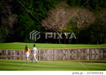 ゴルフを楽しむ40代の夫婦 107899388