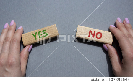 Yes or No symbol. Concept word Yes or No on wooden blocks. Businessman hand. Beautiful grey background. Business and Yes or No concept. Copy space Yes or No symbol. Concept word Yes or No on wooden blocks. Businessman hand. Beautiful grey background. Business and Yes or No concept. Copy space 107899648