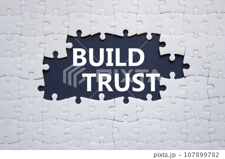 Build trust symbol. White puzzle with words Build trust. Beautiful dark blue background. Business and Build trust concept. Copy space. Build trust symbol. White puzzle with words Build trust. Beautiful dark blue background. Business and Build trust concept. Copy space. 107899782