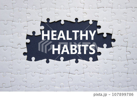 Healthy habits symbol. Concept word Healthy habits on white puzzle blocks. Beautiful dark blue background. Business and Healthy habits concept. Copy space 107899786
