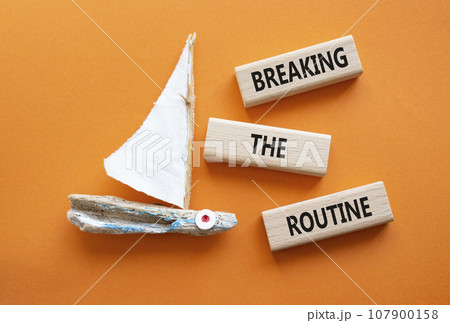 Breaking the Routine week symbol. Concept words Breaking the Routine on wooden blocks. Beautiful orange background with boat. Business and Breaking the Routine concept. Copy space 107900158