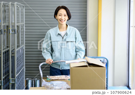 倉庫で棚卸しする作業着の女性作業員 107900624