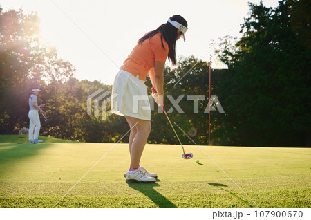 ゴルフを楽しむ40代女性 107900670
