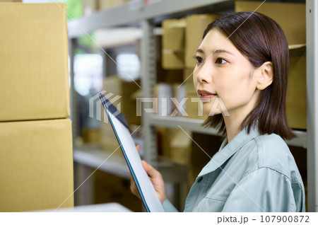 荷物を確認する棚卸中の女性作業員 荷物を確認する棚卸中の女性作業員 107900872