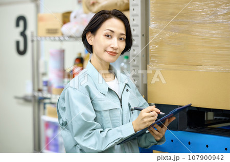 荷物を確認する棚卸中の女性作業員 荷物を確認する棚卸中の女性作業員 107900942