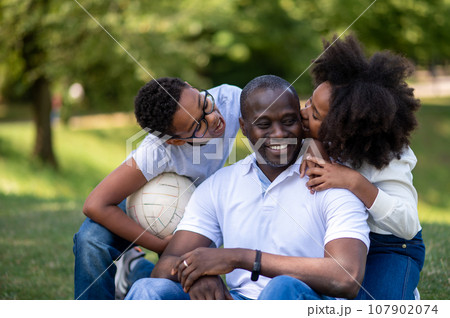 Happy family having a walk in the park and looking contented Happy family having a walk in the park and looking contented 107902074