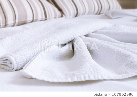White towel on bed in guest room in hotel White towel on bed in guest room in hotel 107902990