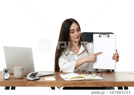 businesswoman in formal wear showing empty clipboard 107903255