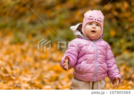 Baby girl, wear pink jacket walking at park Baby girl, wear pink jacket walking at park 107905069