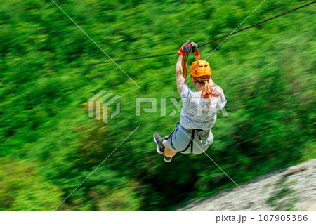 Women Enjoying Thrilling Zipline Experience, Embracing the Exhilaration of Activity-filled Vacation 107905386