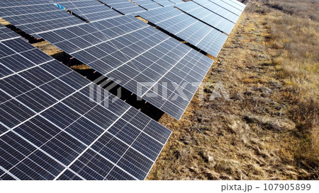 Solar power plant. Flight over modules of solar power station on sunny day. Alternative green electricity power. New modern technology. Renewable electrical energy. photovoltaic modules photobatteries Solar power plant. Flight over modules of solar power station on sunny day. Alternative green electricity power. New modern technology. Renewable electrical energy. photovoltaic modules photobatteries 107905899