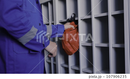 Medicine worker in blue uniform putting red bag in spare place. Clip. Emergency worker in uniform. Medicine worker in blue uniform putting red bag in spare place. Clip. Emergency worker in uniform. 107906235