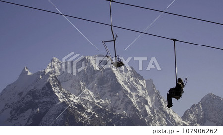 Low angle view of ski resort, slopes and lift. Creative. Chairlift transporting people to the top of the mountain, skiing in beautiful ski resort. Low angle view of ski resort, slopes and lift. Creative. Chairlift transporting people to the top of the mountain, skiing in beautiful ski resort. 107906262