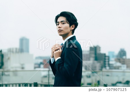 都会でネクタイを整える若いビジネスマン 107907125