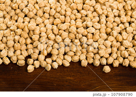 Closeup of background with raw garbanzo grains on wooden surface Closeup of background with raw garbanzo grains on wooden surface 107908790