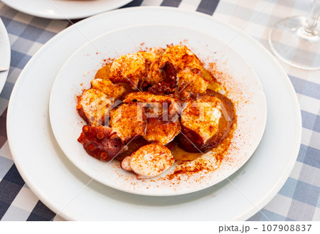 Galician boiled octopus with smoked paprika and potato slices Galician boiled octopus with smoked paprika and potato slices 107908837