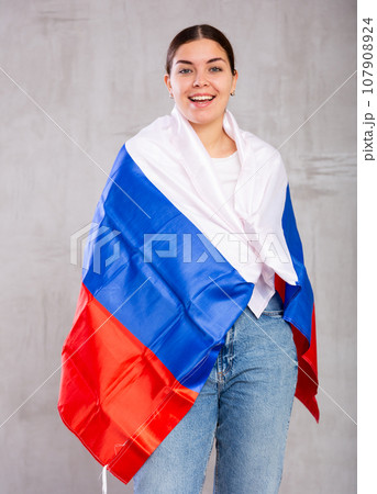Portrait of positive young woman with flag of Russia 107908924