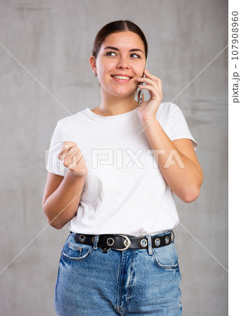 Smiling young woman talking on mobile phone Smiling young woman talking on mobile phone 107908960