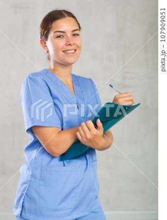 Positive nurse filling out medical history forms in documents 107909051