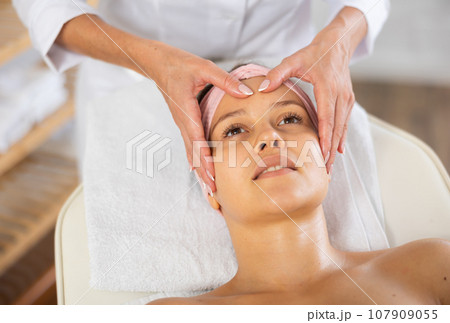Young woman getting facial massage in salon 107909055