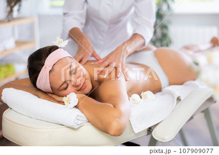 Young woman getting back and shoulder massage 107909077