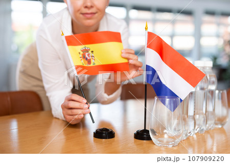 Blurry girl set midget flags of Netherlands and Spain before international negotiations Blurry girl set midget flags of Netherlands and Spain before international negotiations 107909220