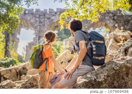 Father and son tourists explores Stunning Ancient Theater of Termessos Ancient City. Traveling with kids concept. turkiye, GO Everywhere 107909486