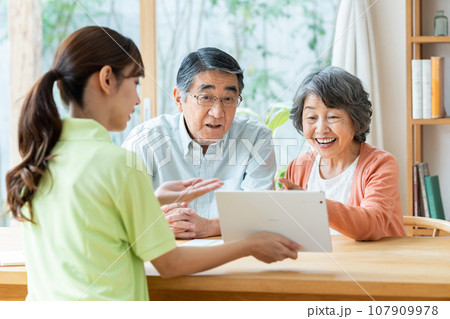 ケアマネージャーから介護プランの説明を受けるシニアの夫婦 ケアマネージャーから介護プランの説明を受けるシニアの夫婦 107909978