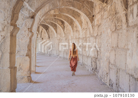 Woman tourist explores Aspendos Ancient City. Aspendos acropolis city ruins, cisterns, aqueducts and old temple. Aspendos Antalya Turkey. turkiye Woman tourist explores Aspendos Ancient City. Aspendos acropolis city ruins, cisterns, aqueducts and old temple. Aspendos Antalya Turkey. turkiye 107910130