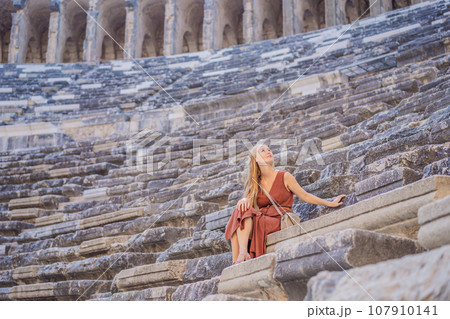 Woman tourist explores Aspendos Ancient City. Aspendos acropolis city ruins, cisterns, aqueducts and old temple. Aspendos Antalya Turkey. turkiye Woman tourist explores Aspendos Ancient City. Aspendos acropolis city ruins, cisterns, aqueducts and old temple. Aspendos Antalya Turkey. turkiye 107910141