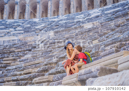 mother and son tourists explores Aspendos Ancient City. Traveling with kids concept. Aspendos acropolis city ruins, cisterns, aqueducts and old temple. Aspendos Antalya Turkey. turkiye mother and son tourists explores Aspendos Ancient City. Traveling with kids concept. Aspendos acropolis city ruins, cisterns, aqueducts and old temple. Aspendos Antalya Turkey. turkiye 107910142